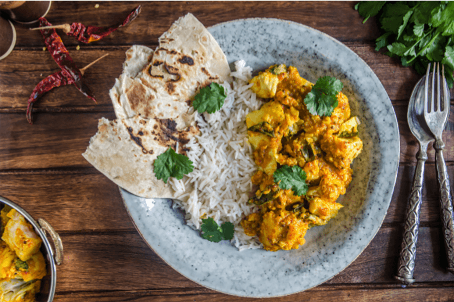 Curry rice and naan break on a table ready to be eaten.